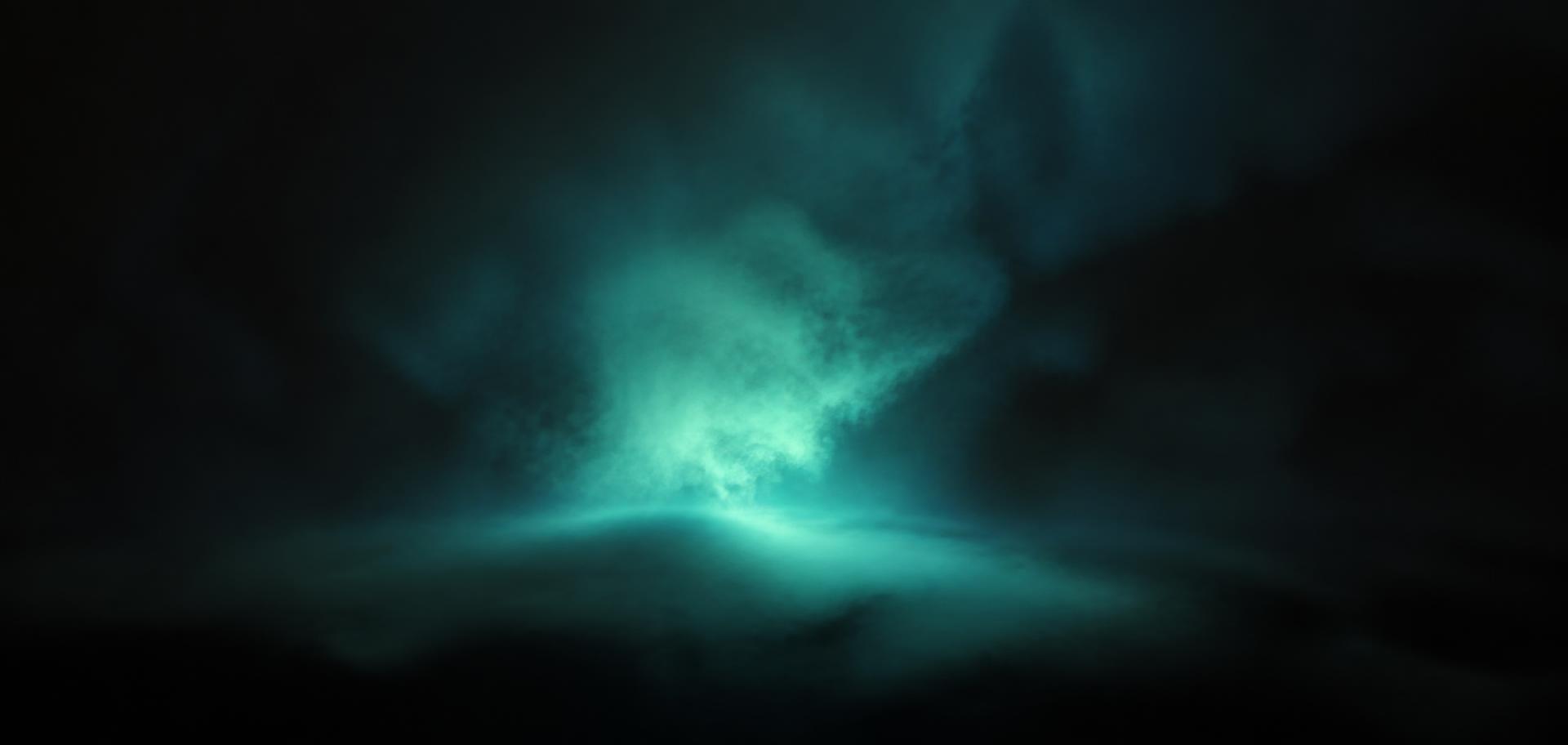 Luminous cyan light glowing through dark atmospheric fog